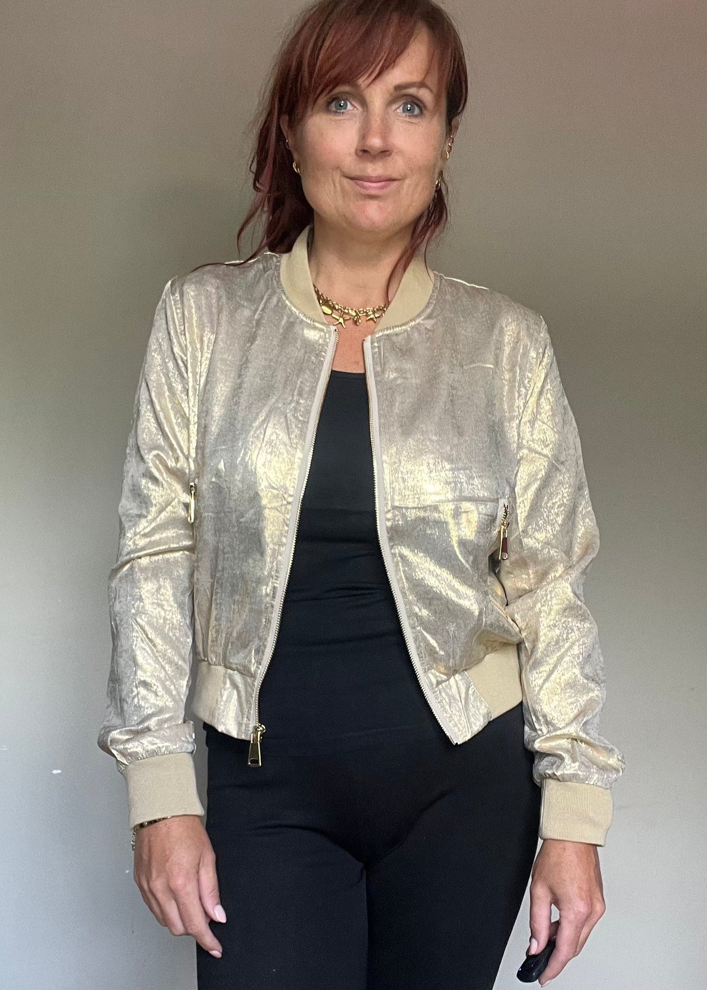 Metallic bomberjasje in goud of zilver met rits en steekzakken. Trendy, vrouwelijk model voor zomer en najaar.
