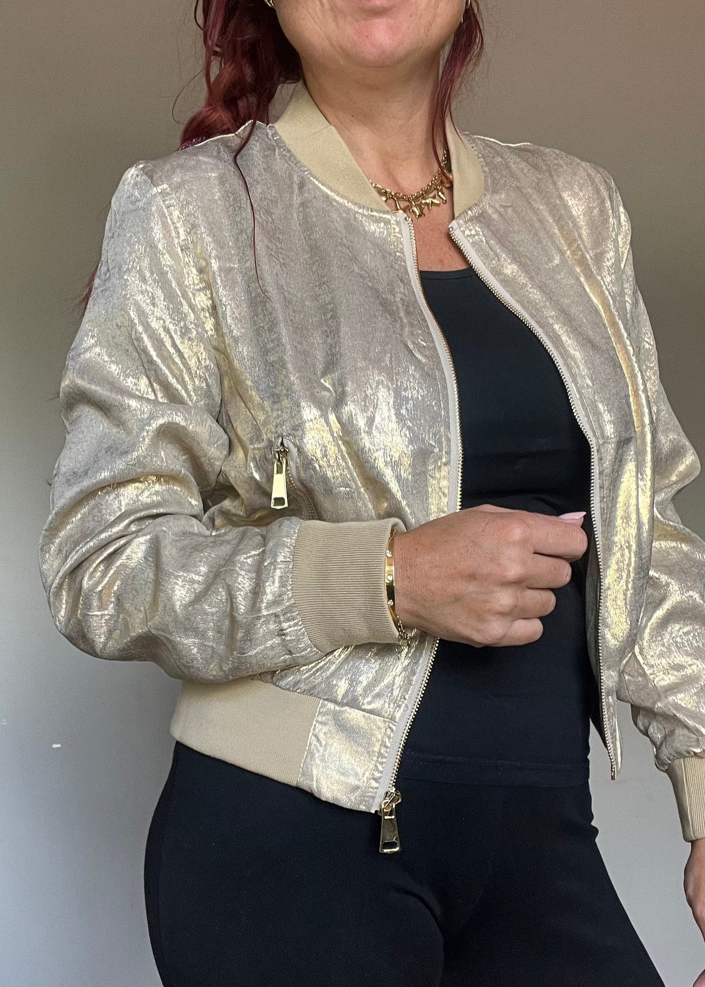 Metallic bomberjasje in goud of zilver met rits en steekzakken. Trendy, vrouwelijk model voor zomer en najaar.