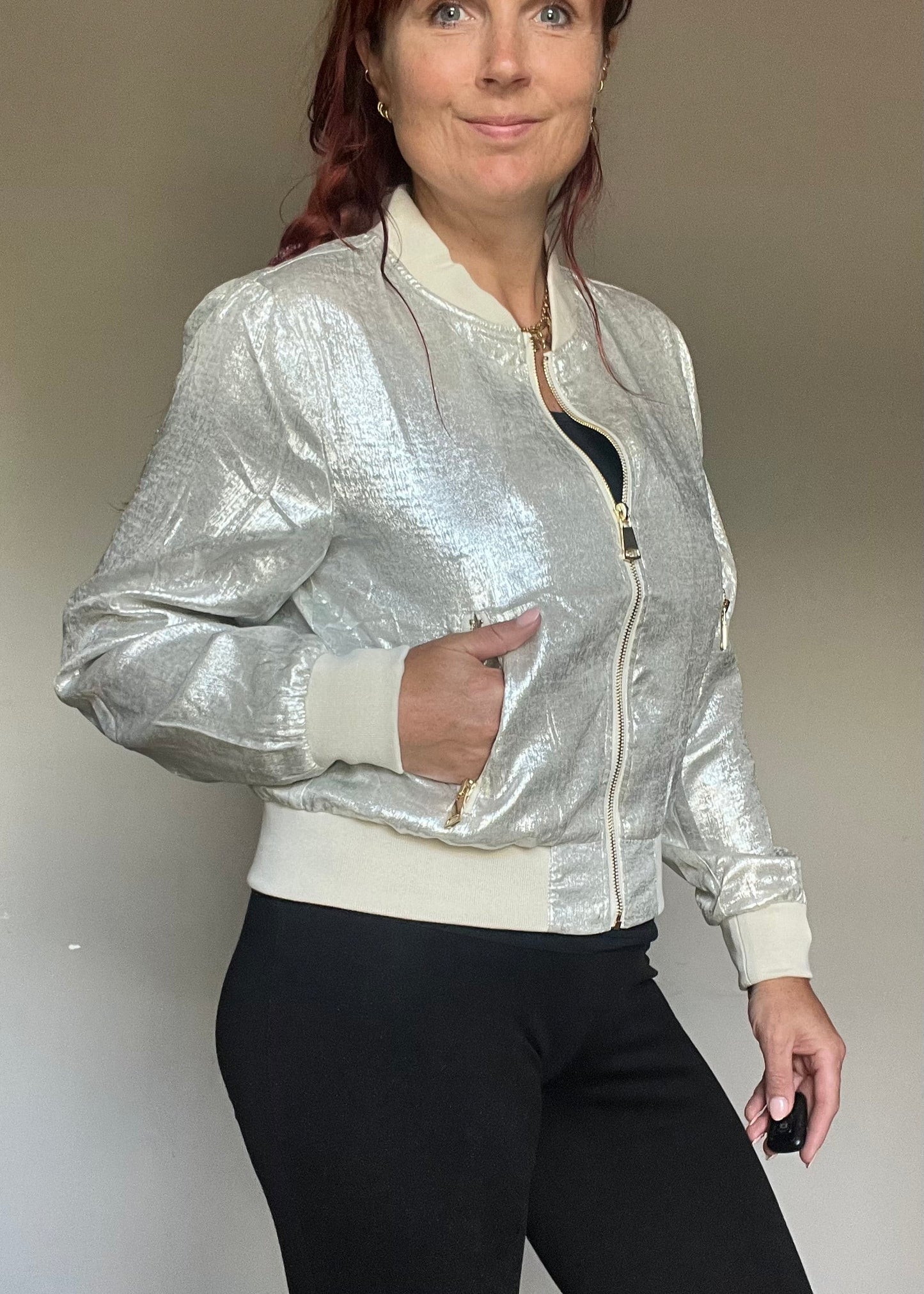 Metallic bomberjasje in goud of zilver met rits en steekzakken. Trendy, vrouwelijk model voor zomer en najaar.