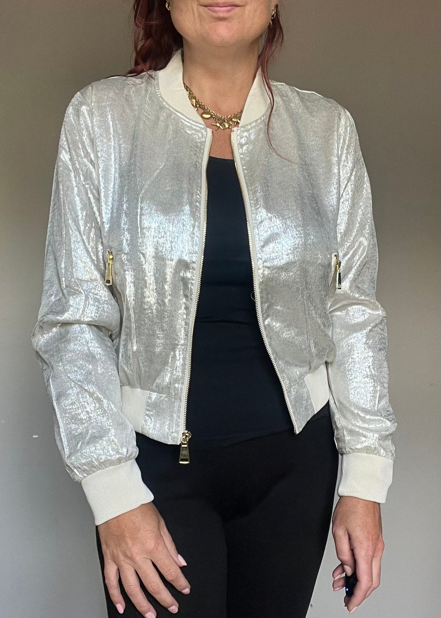 Metallic bomberjasje in goud of zilver met rits en steekzakken. Trendy, vrouwelijk model voor zomer en najaar.