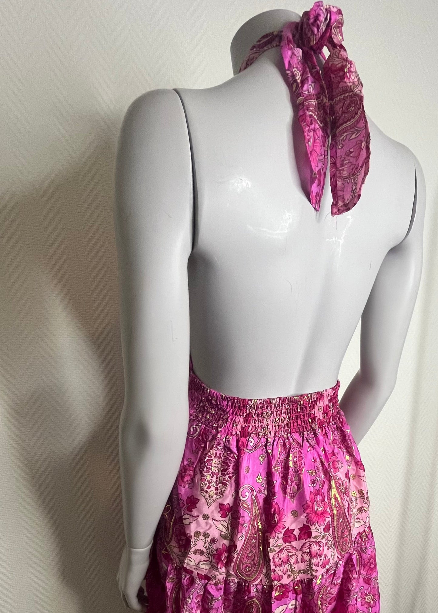 Zomerse damesjurk met blote rug en halssluiting, polyester stof in drie kleurrijke prints, licht, speels en vrouwelijk.