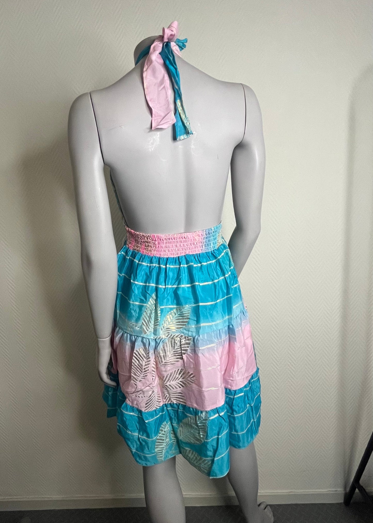 Zomerse damesjurk met blote rug en halssluiting, polyester stof in drie kleurrijke prints, licht, speels en vrouwelijk.
