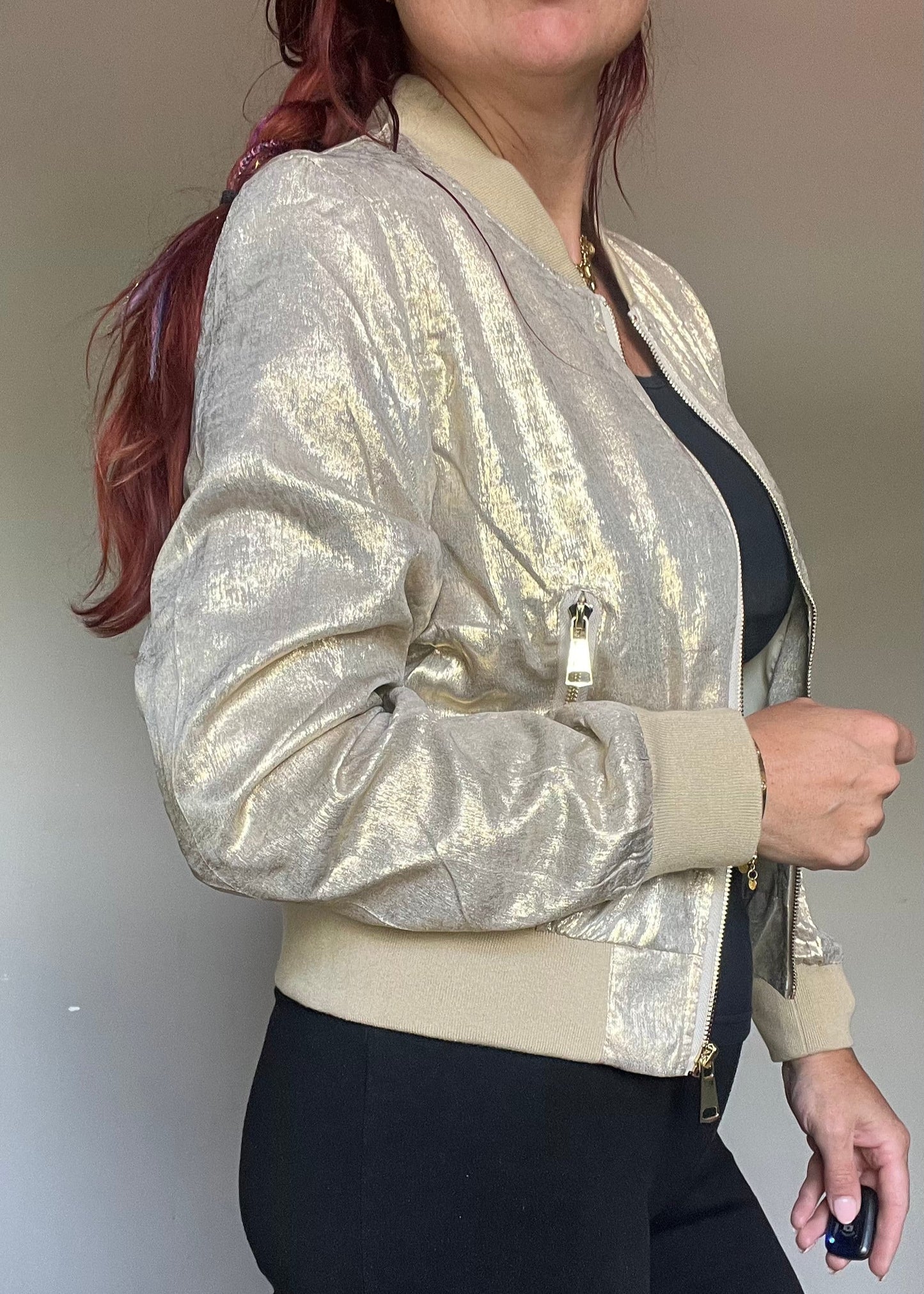 Metallic bomberjasje in goud of zilver met rits en steekzakken. Trendy, vrouwelijk model voor zomer en najaar.