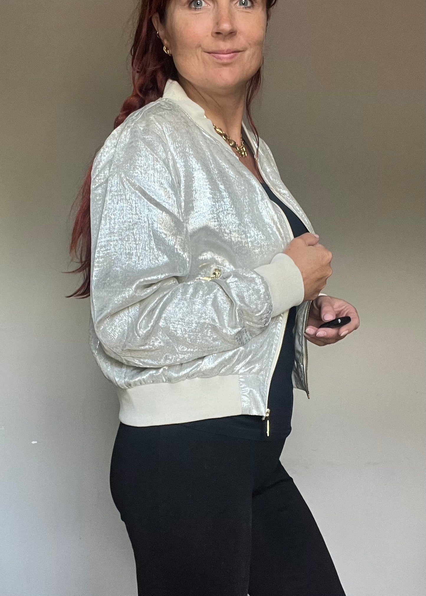 Metallic bomberjasje in goud of zilver met rits en steekzakken. Trendy, vrouwelijk model voor zomer en najaar.