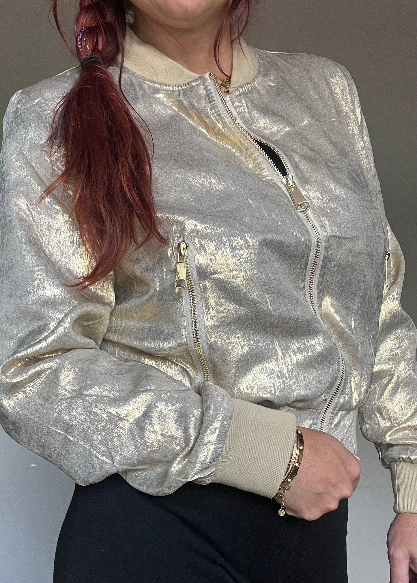 Metallic bomberjasje in goud of zilver met rits en steekzakken. Trendy, vrouwelijk model voor zomer en najaar.