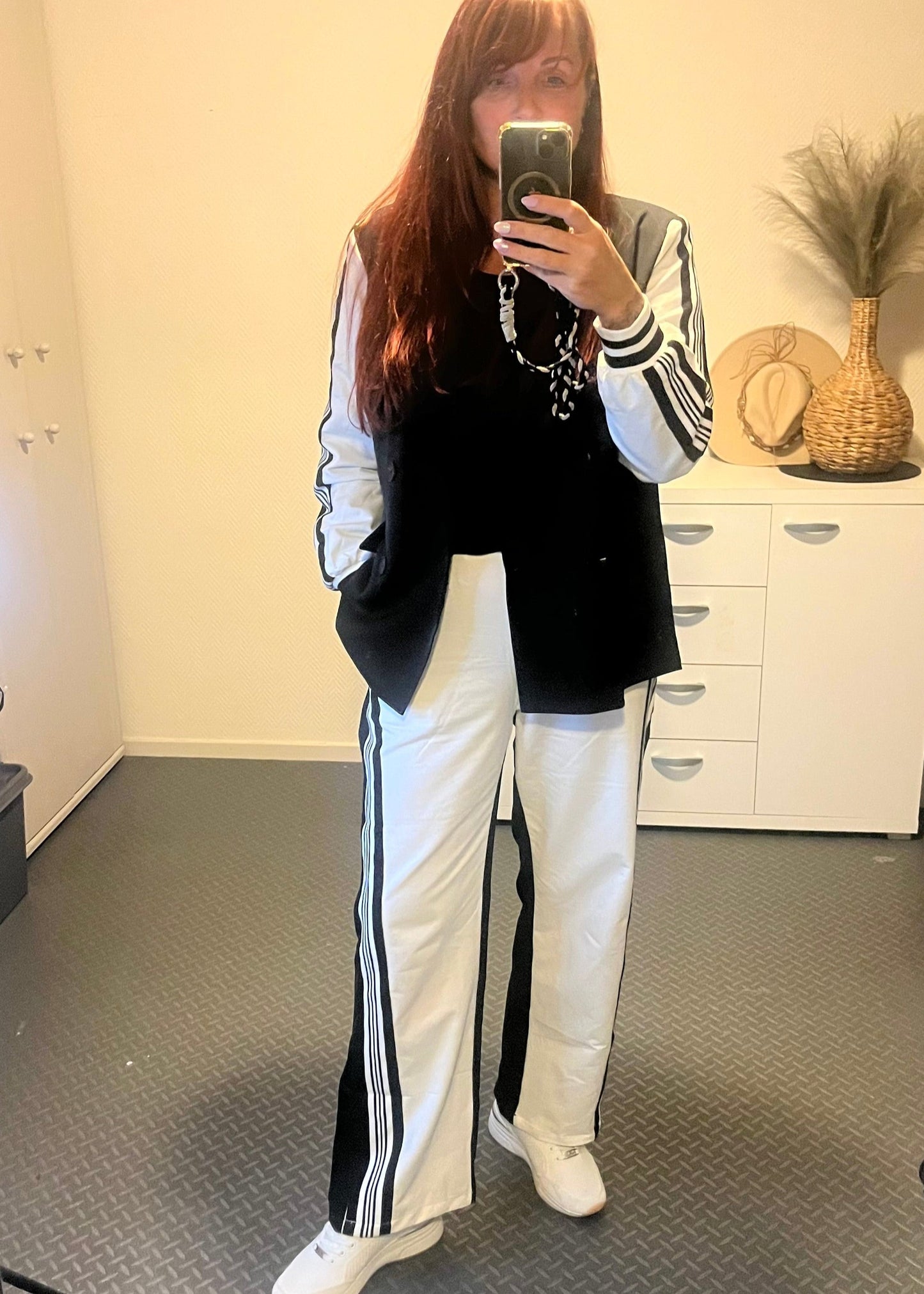 Tweedelige set zwart-wit met jasje en broek. Jasje met knopen en zakken, broek met elastische tailleband en steekzakken. One size tot maat 42.