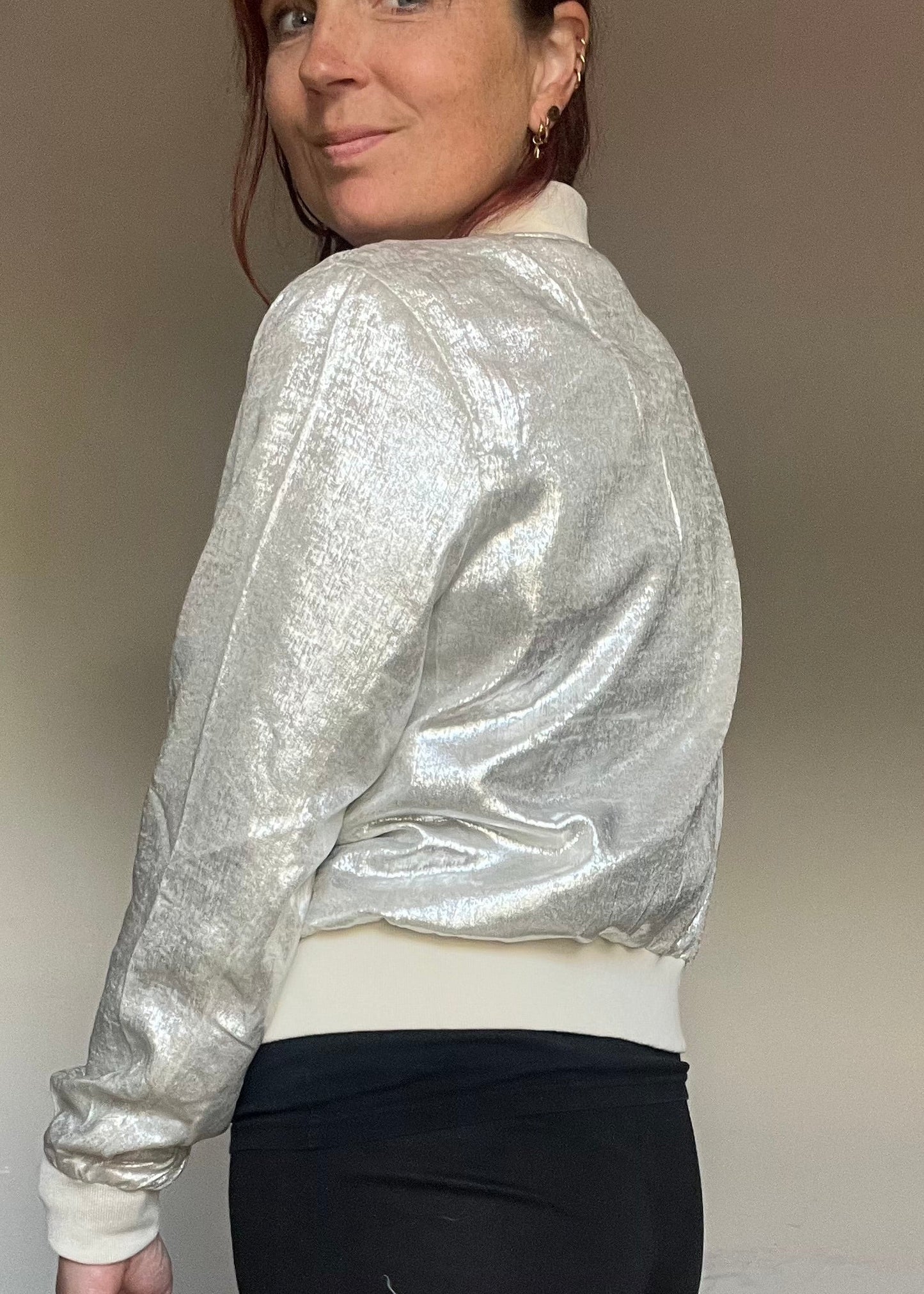 Metallic bomberjasje in goud of zilver met rits en steekzakken. Trendy, vrouwelijk model voor zomer en najaar.