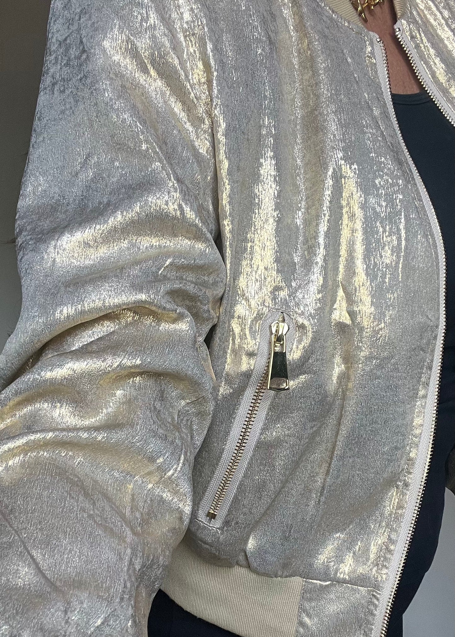 Metallic bomberjasje in goud of zilver met rits en steekzakken. Trendy, vrouwelijk model voor zomer en najaar.