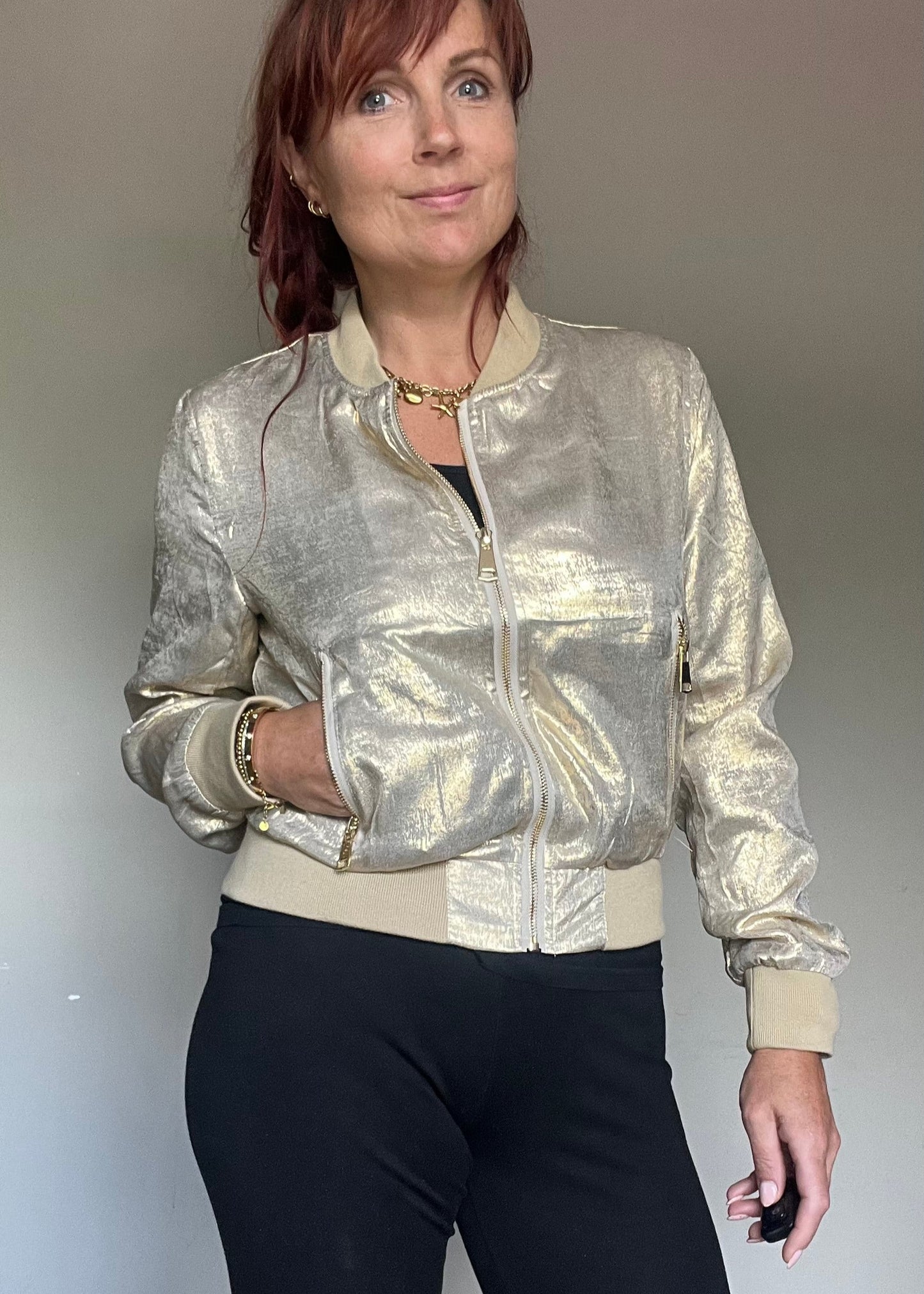 Metallic bomberjasje in goud of zilver met rits en steekzakken. Trendy, vrouwelijk model voor zomer en najaar.