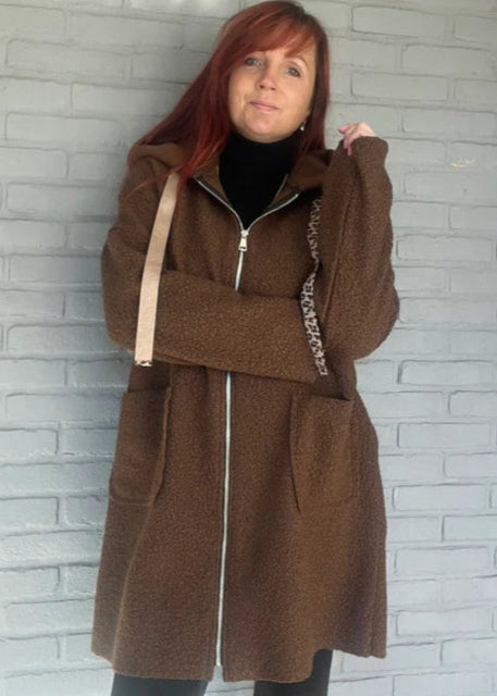 Bruin langer model jasje van wollige stof met rits, capuchon en zakken. Oversized fit, one size tot maat 44.