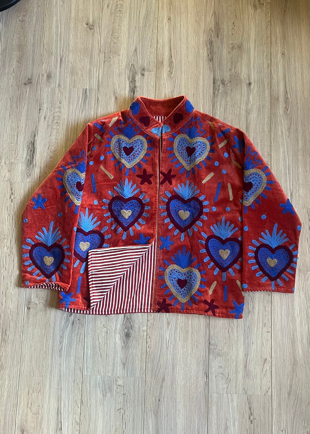 Handgemaakte velvet Suzani jacket uit India met kleurrijk borduurwerk in terracotta met blauw.