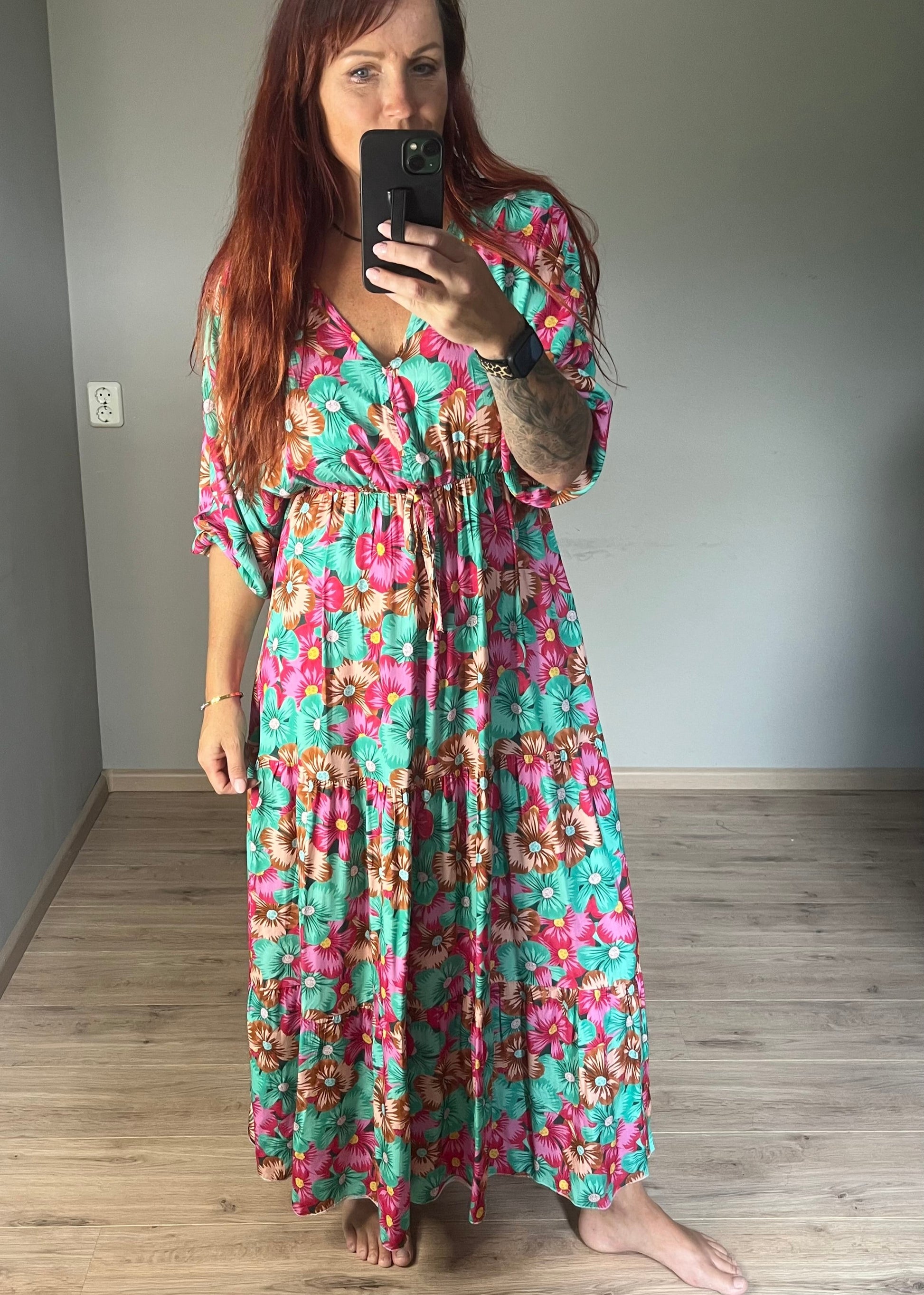 Vrouwelijke zomerjurk van viscose met knalkleuren print, elastiek onder de borst en wijde mouwen. Luchtig model, knoopsluiting op de rug.