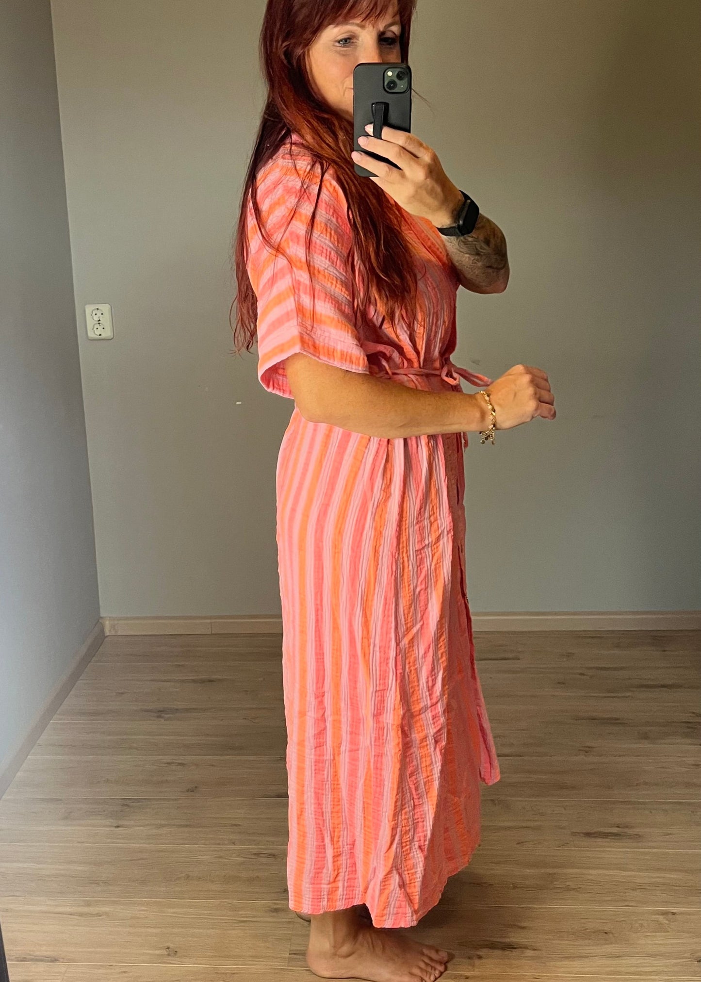 Maxi jurk van mousseline katoen in leuke zomerse felle kleurcomibinatie. Helemaal in de Ibiza vibe, doorknoopmodel met riempje. In 3 maten.