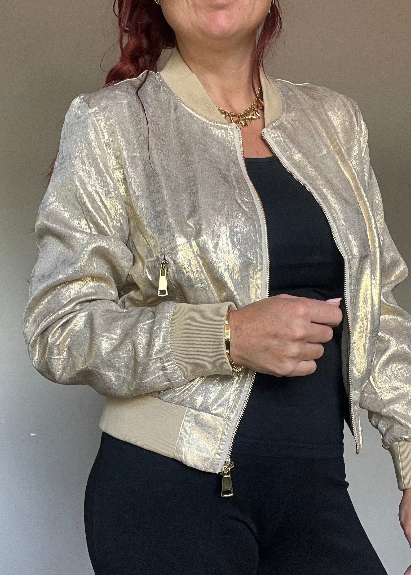 Metallic bomberjasje in goud of zilver met rits en steekzakken. Trendy, vrouwelijk model voor zomer en najaar.