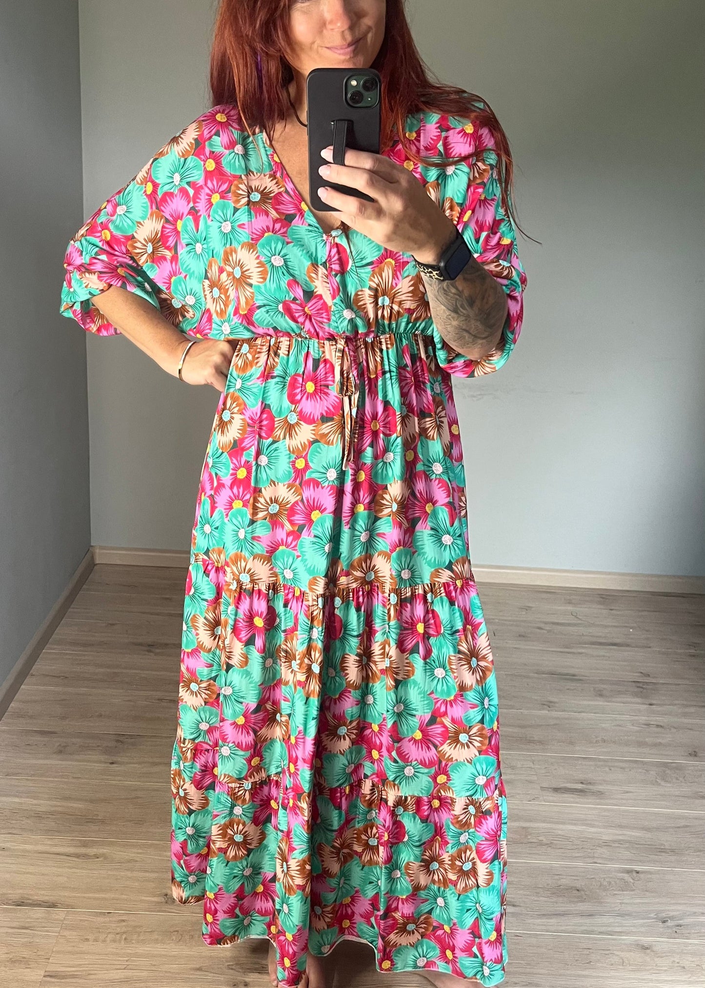 Vrouwelijke zomerjurk van viscose met knalkleuren print, elastiek onder de borst en wijde mouwen. Luchtig model, knoopsluiting op de rug.