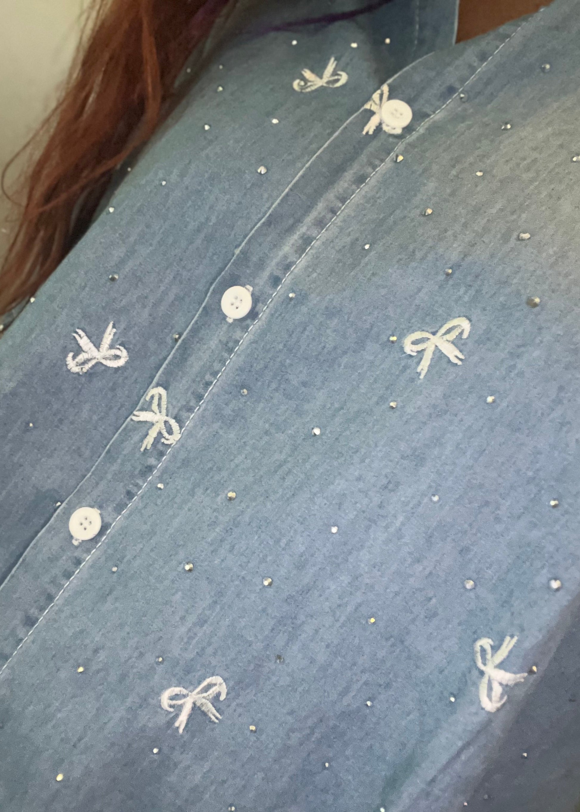 Oversized damesblouse van denim met strikjes en glitters, gemaakt van katoen. One size, passend tot maat 46.
