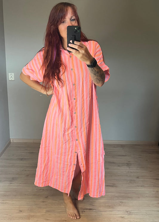 Maxi jurk van mousseline katoen in leuke zomerse felle kleurcomibinatie. Helemaal in de Ibiza vibe, doorknoopmodel met riempje. In 3 maten.