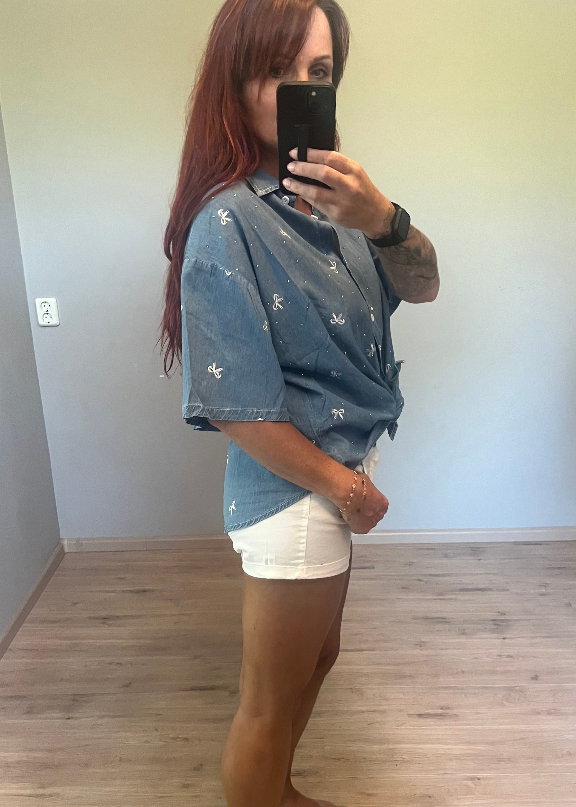 Oversized damesblouse van denim met strikjes en glitters, gemaakt van katoen. One size, passend tot maat 46.
