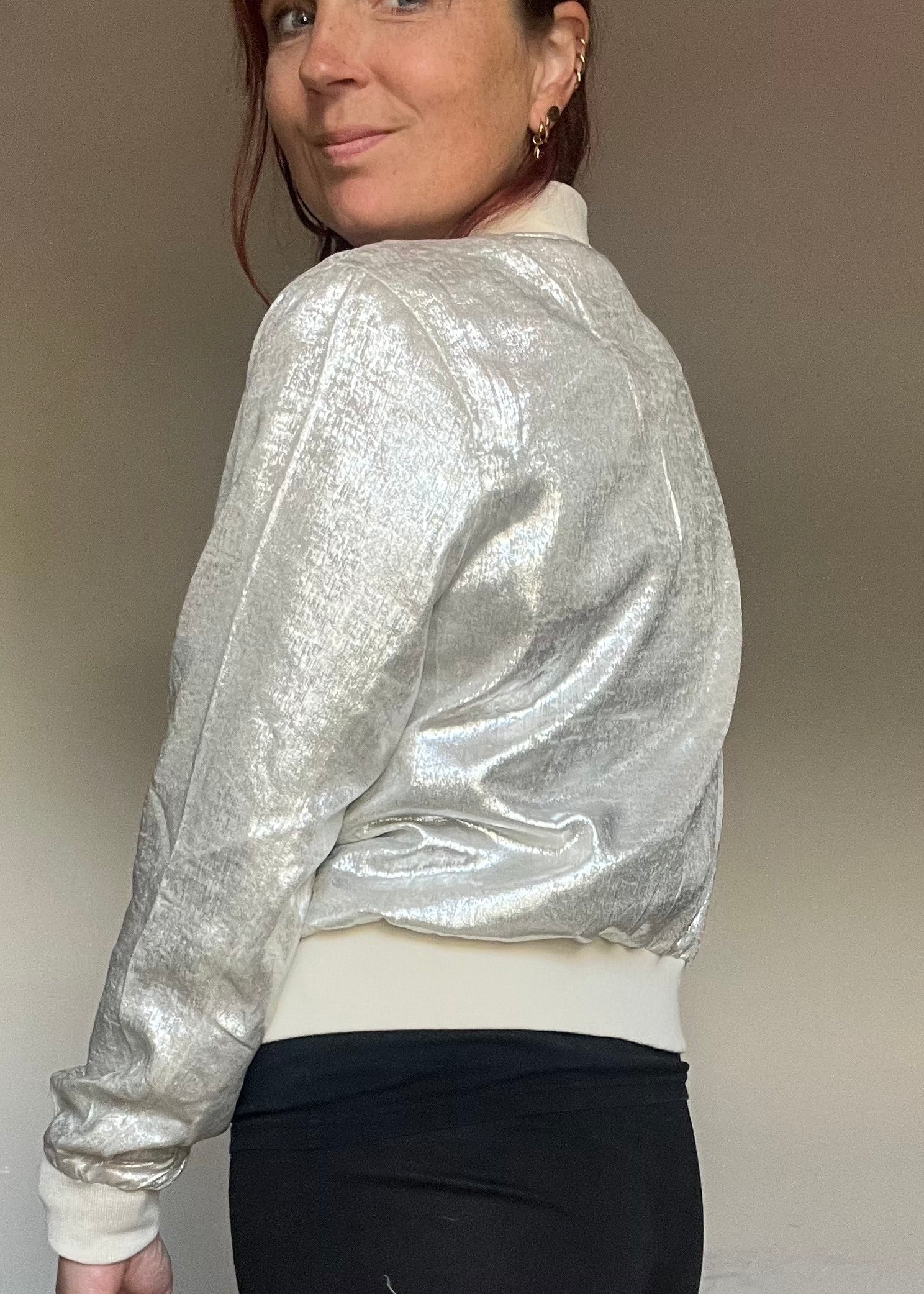 Metallic bomberjasje in goud of zilver met rits en steekzakken. Trendy, vrouwelijk model voor zomer en najaar.