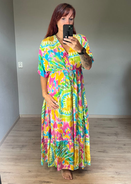 Vrouwelijke zomerjurk van viscose met knalkleuren print, elastiek onder de borst en wijde mouwen. Luchtig model, knoopsluiting op de rug.