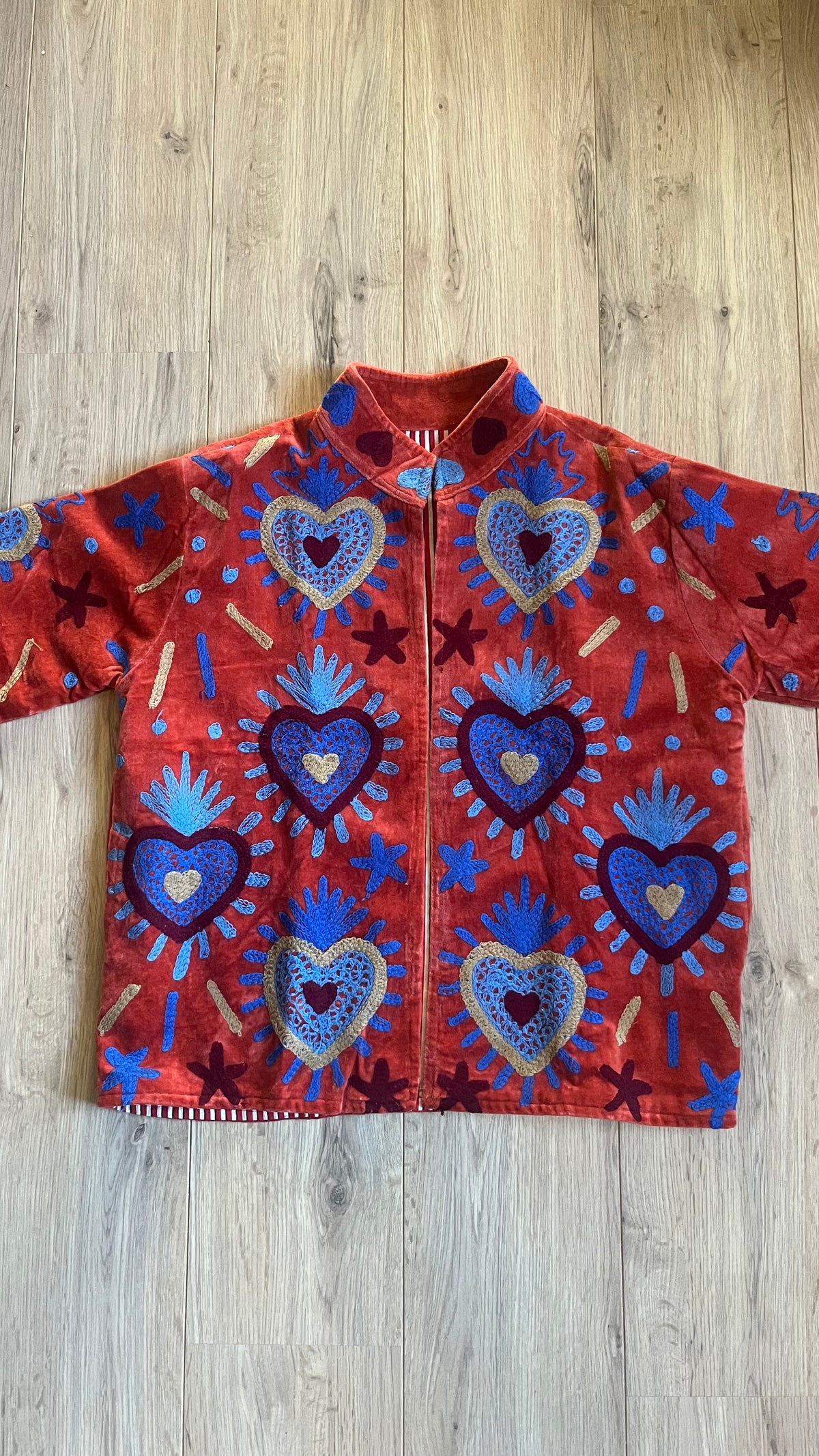 Handgemaakte velvet Suzani jacket uit India met kleurrijk borduurwerk in terracotta met blauw.