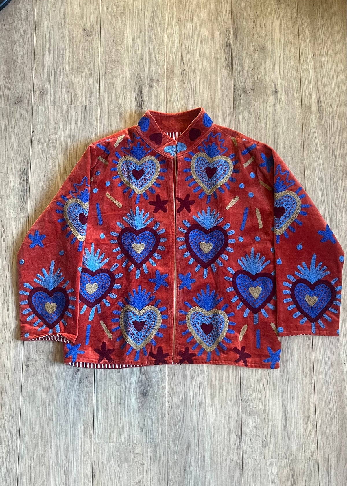 Handgemaakte velvet Suzani jacket uit India met kleurrijk borduurwerk in terracotta met blauw.