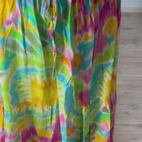 Vrouwelijke zomerjurk van viscose met knalkleuren print, elastiek onder de borst en wijde mouwen. Luchtig model, knoopsluiting op de rug.
