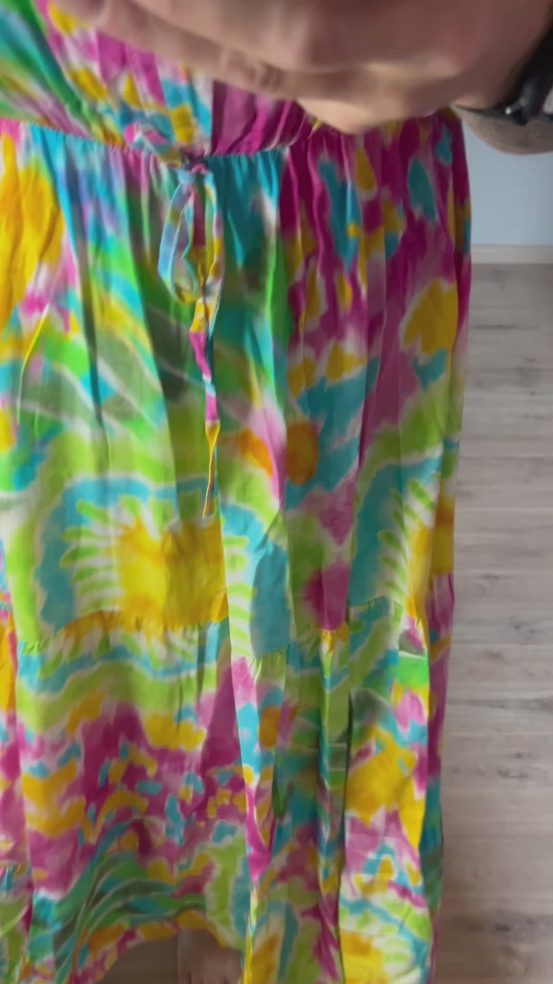 Vrouwelijke zomerjurk van viscose met knalkleuren print, elastiek onder de borst en wijde mouwen. Luchtig model, knoopsluiting op de rug.