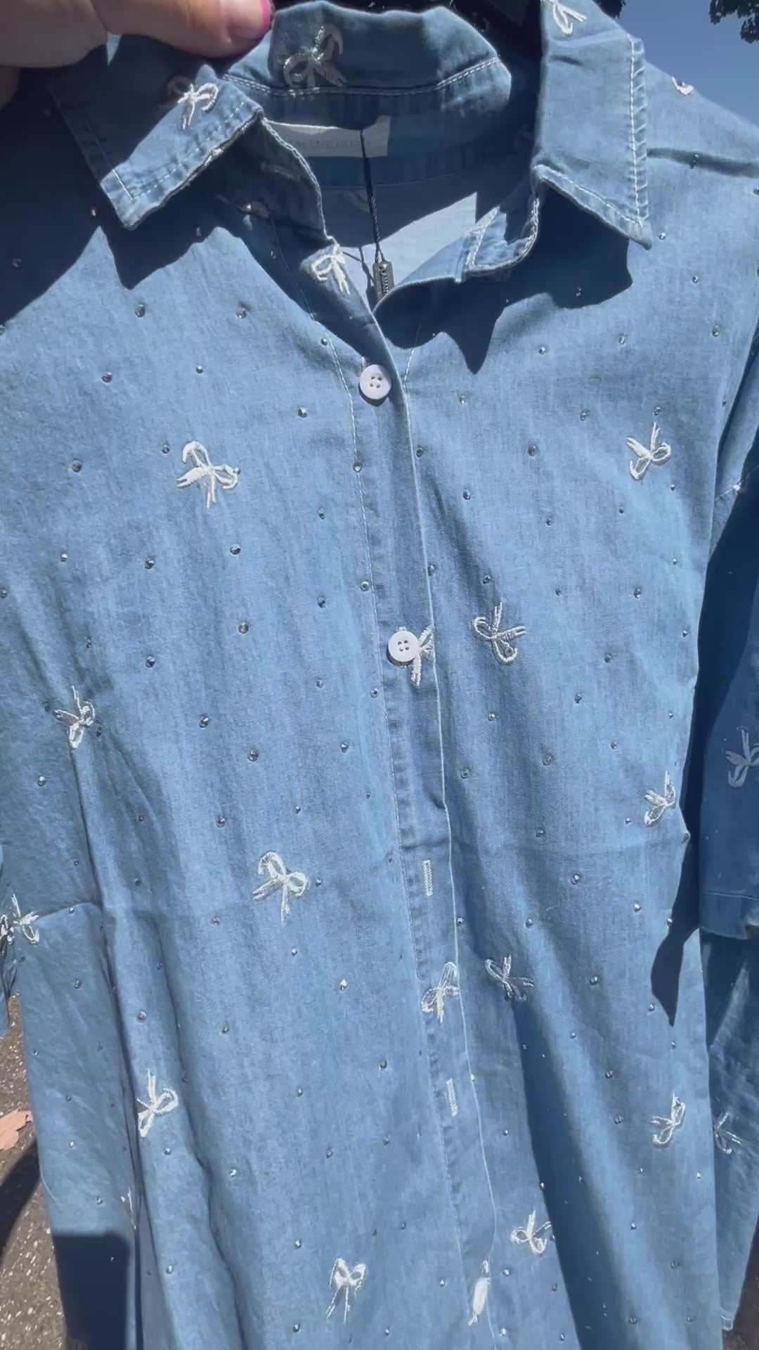 Oversized damesblouse van denim met strikjes en glitters, gemaakt van katoen. One size, passend tot maat 46.